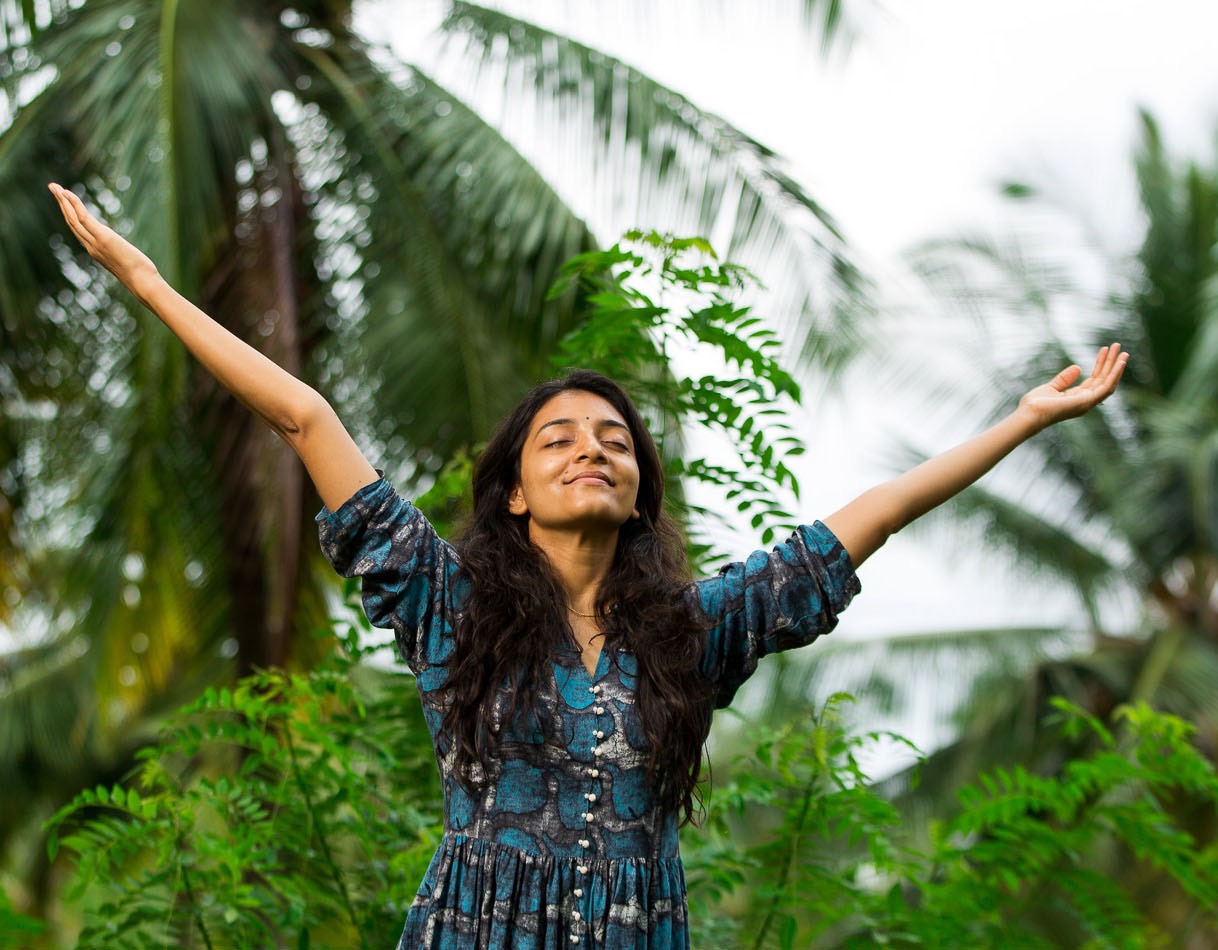 Smiling woman with raised arms feeling grateful copy