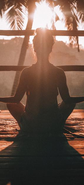 Backpain - A lady meditating facing sunrise