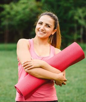 Women ready for yoga holding yoga mat in hand