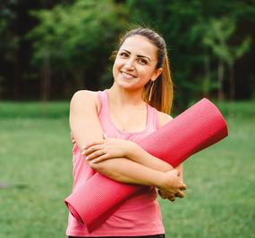 Women ready for yoga holding yoga mat in hand