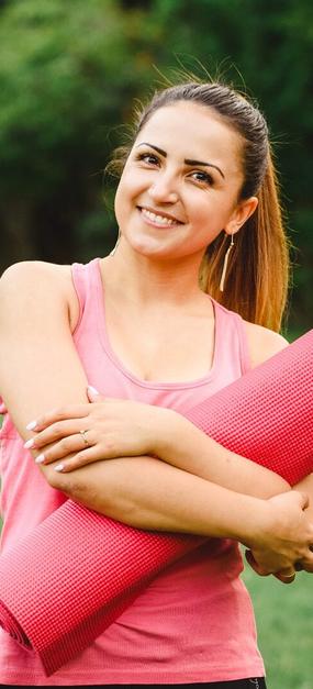 Women ready for yoga holding yoga mat in hand