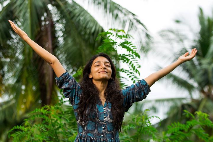 Smiling woman with raised arms feeling grateful copy